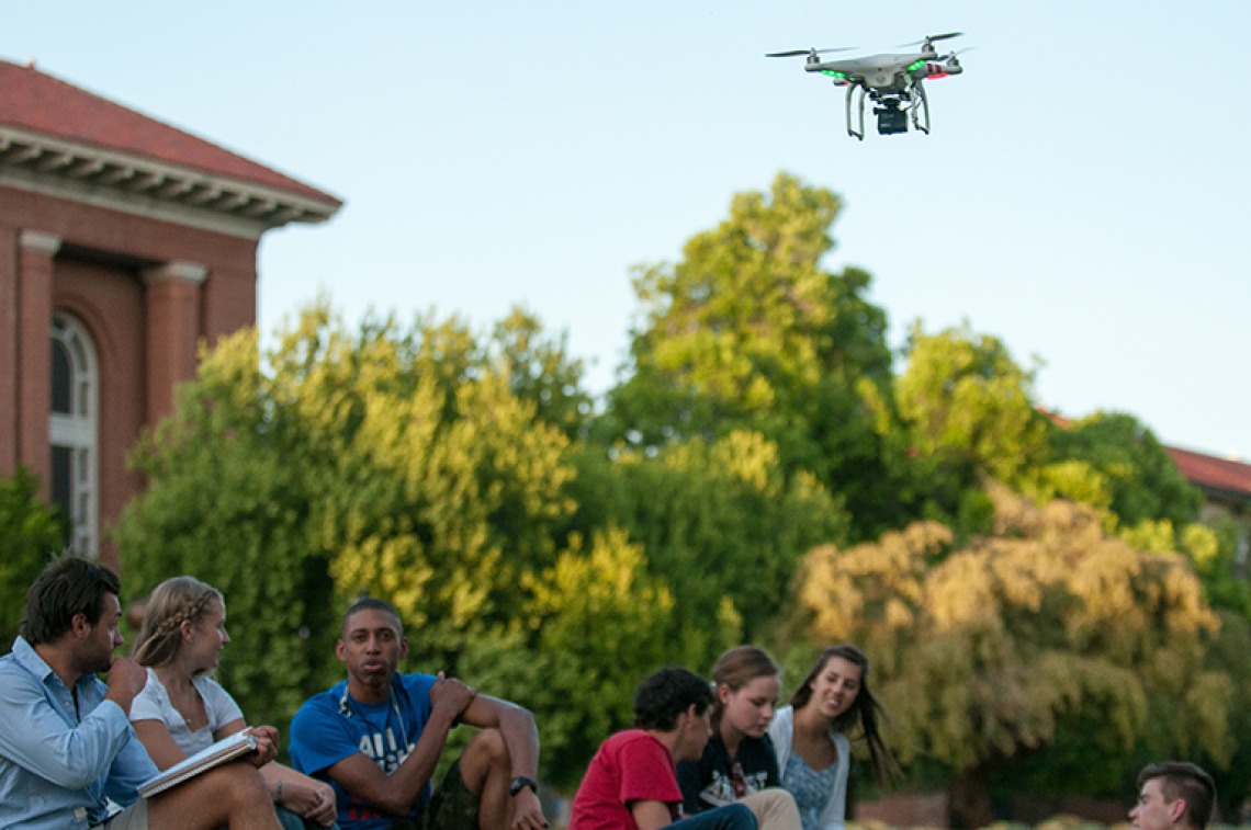 A drone with camera hovers over campus